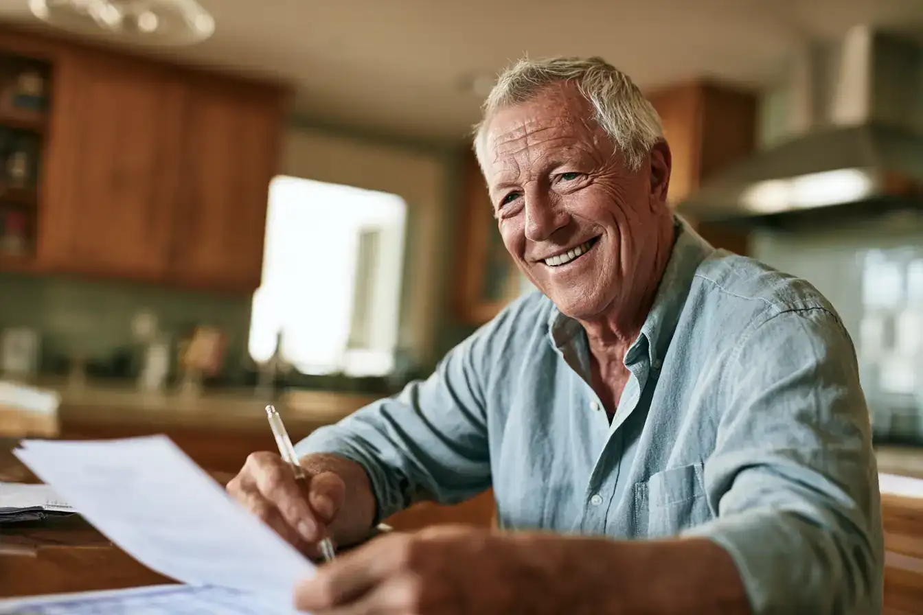 An Asian man in his fifties with a printed report and a pen on a kitchen table