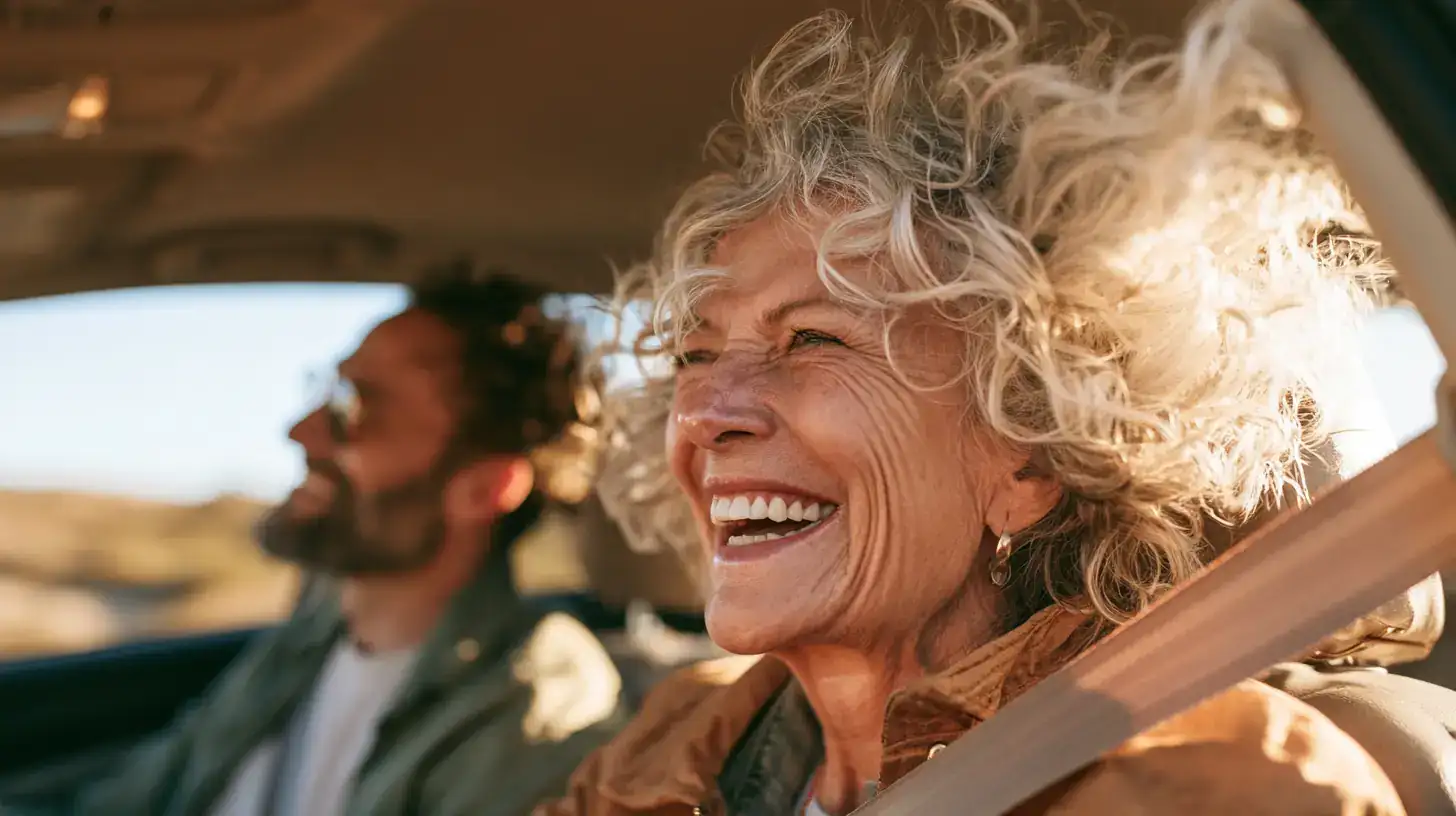 A white woman in her seventies and her adult son driving together, passenger turned toward the driver