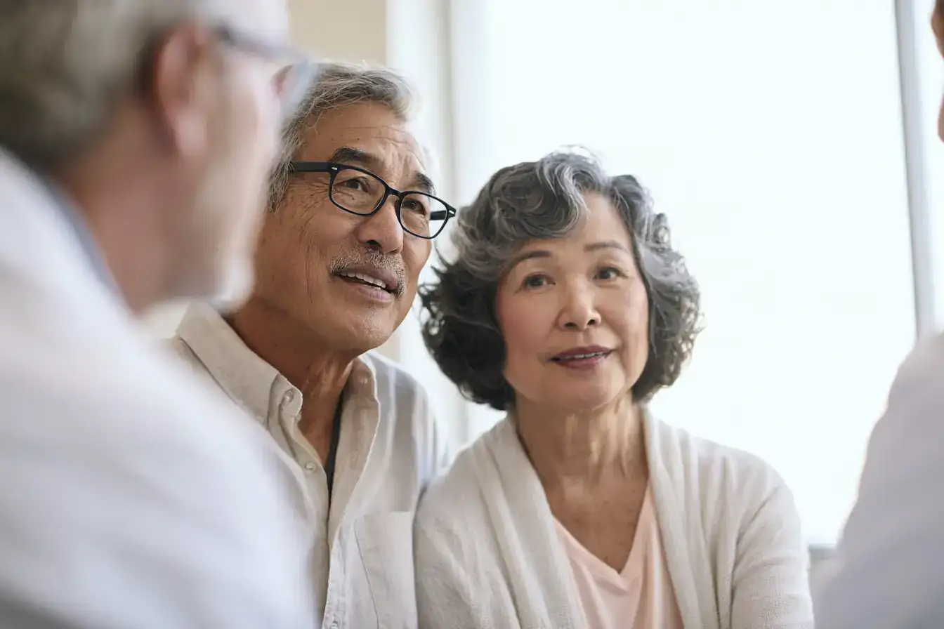 An Asian couple in their seventies talking things through wit