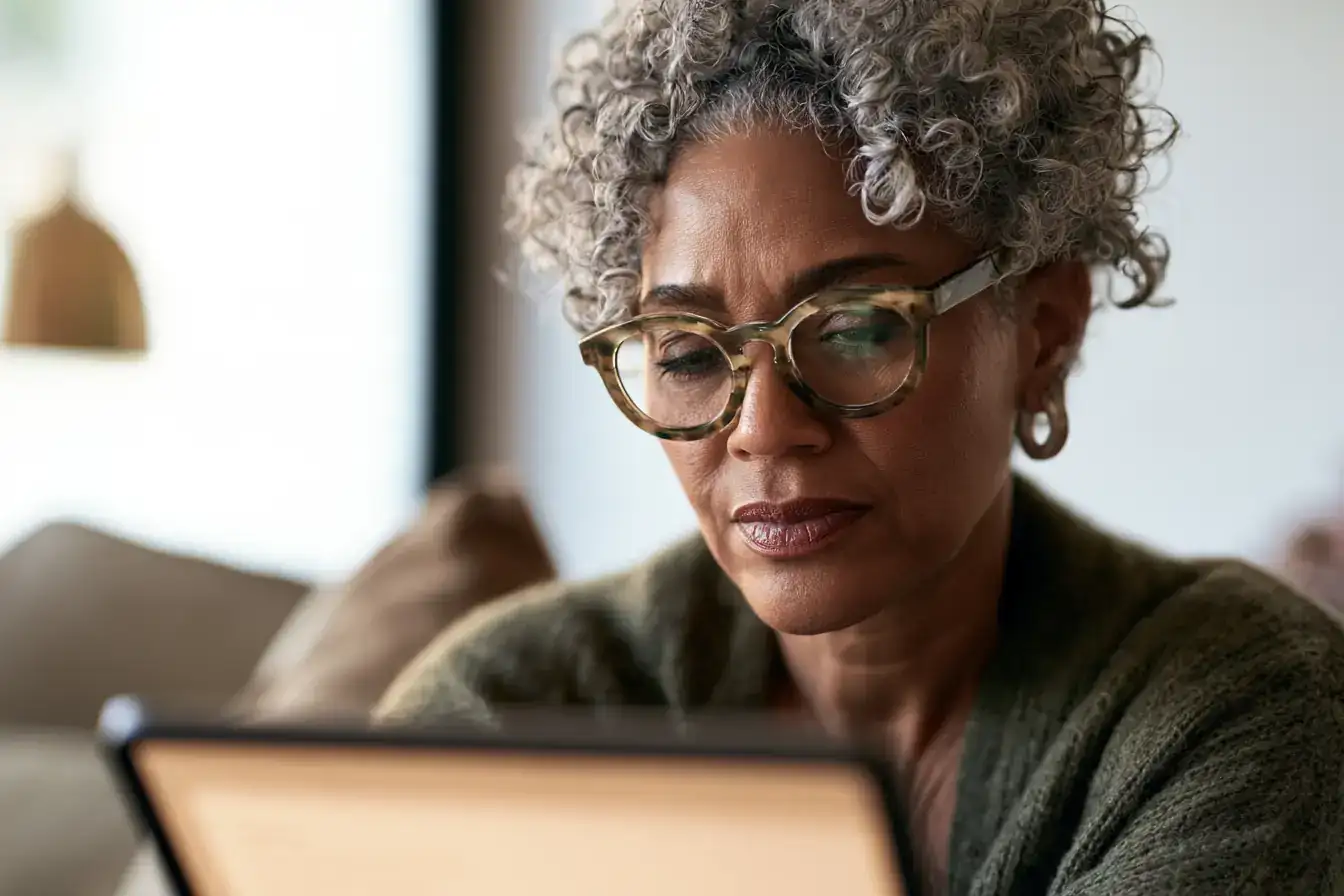 A Black woman in her fifties comparing two results side by side on paper