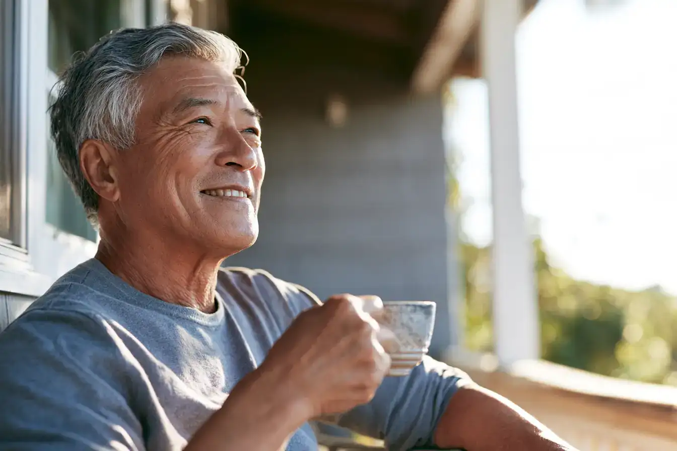 A Black man in his fifties stretching by an open window at first light